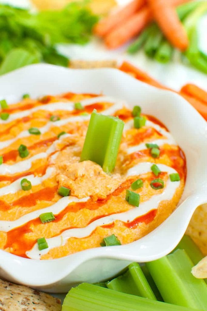 Piece of celery dipped into a bowl of slow cooker buffalo chicken dip