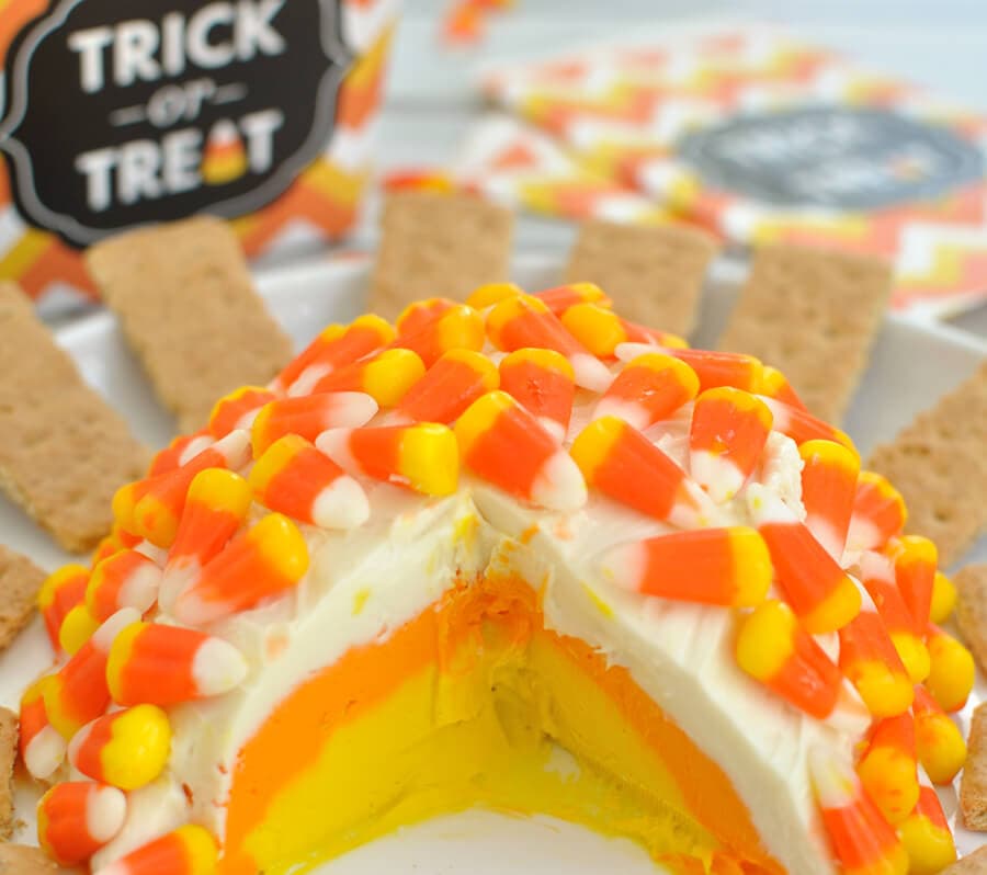 Candy corn cheesecake cheese ball recipe that features white, orange, and yellow layers just like the candy. This is a great fall dessert for Halloween.