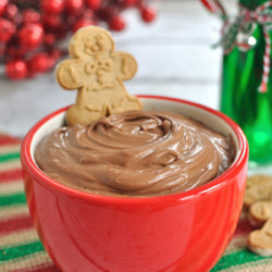 Bowl of chocolate eggnog dip with a gingerbread man dipped in