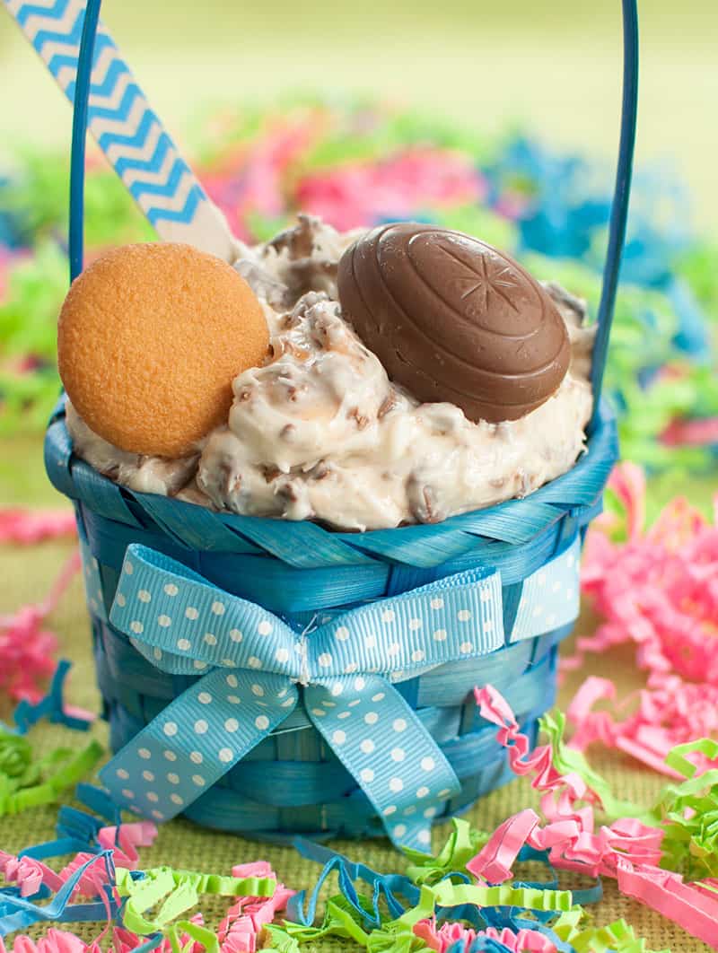 Small blue Easter basket filled with Cadbury Creme Egg Dip and topped with a vanilla wafer