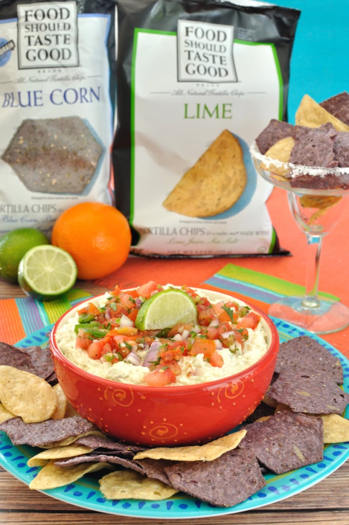 bowl of crock pot margarita chicken dip on a blue plate with tortilla chips