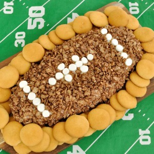 Fun appetizer or dessert recipe for game day. This Cocoa Krispie Treat Football Cheese Ball combines the flavor of marshmallow with cocoa krispies in a dip.