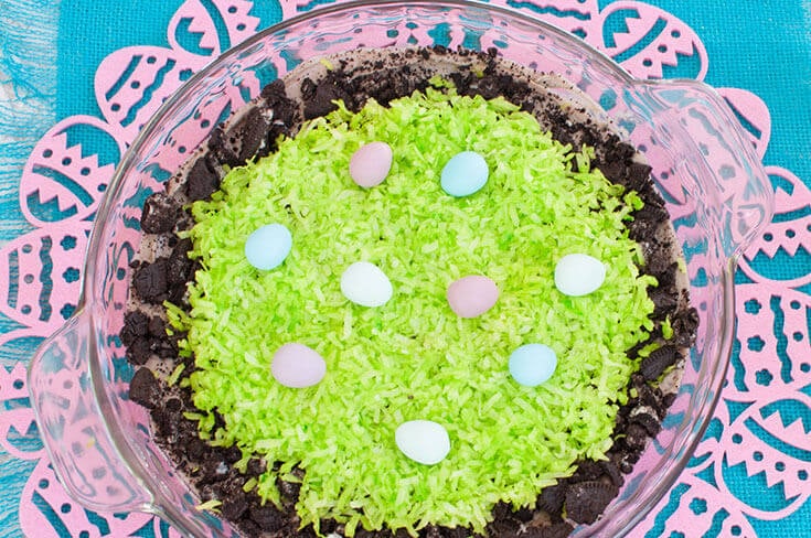 Cookies and cream dessert dip with green shredded coconut and mini chocolate eggs makes a cute Easter dessert.