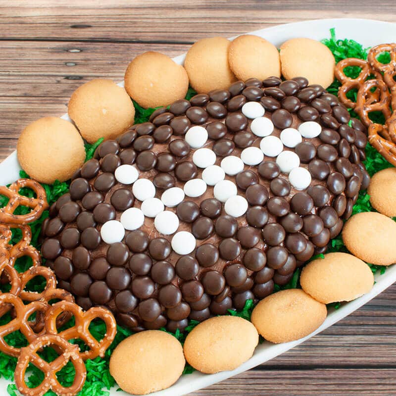 Oval platter with a chocolate dessert cheese ball football and pretzels and vanilla wafers