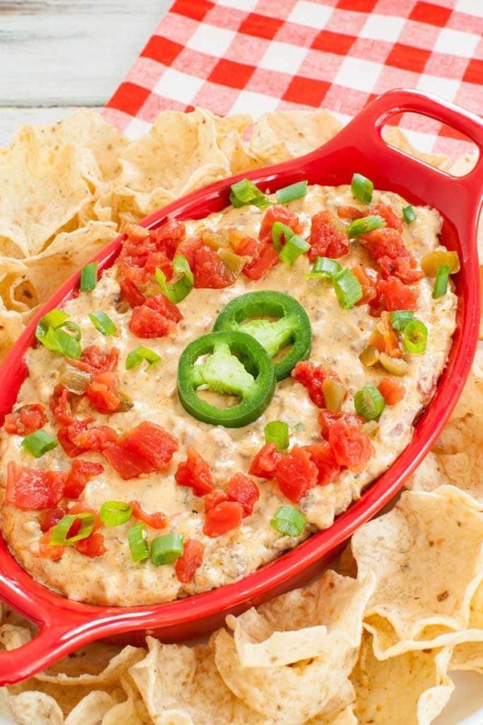 red baking dish of rotel dip made with ground beef topped with jalapenos