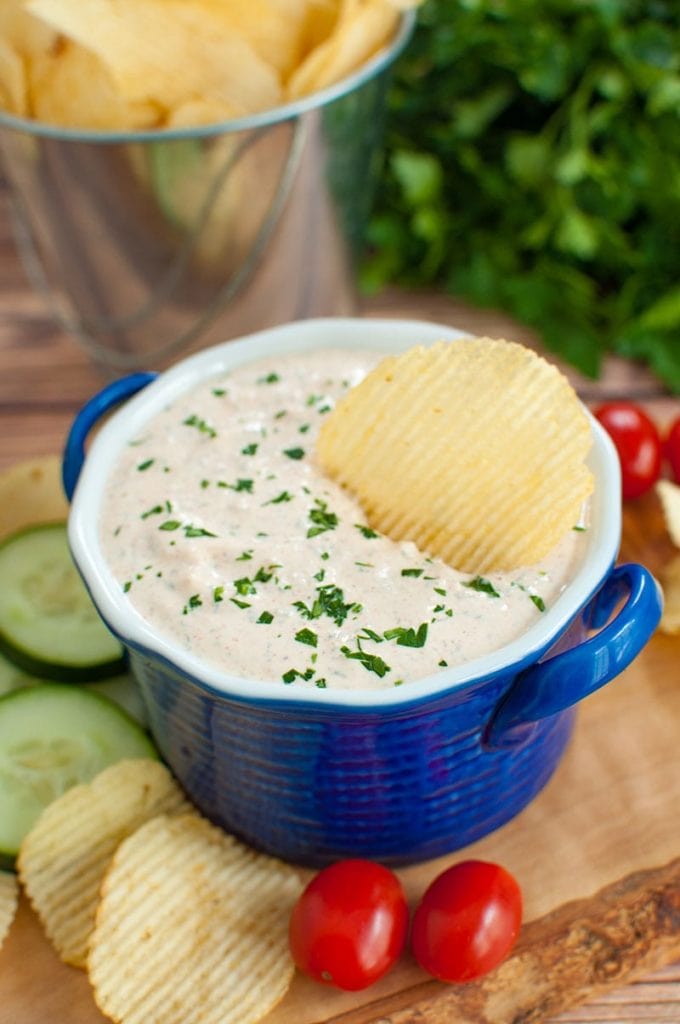 sour cream dip with a chip in a blue bowl