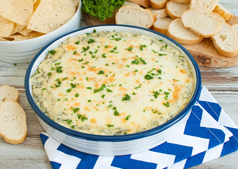 white and blue dish with hot spinach dip