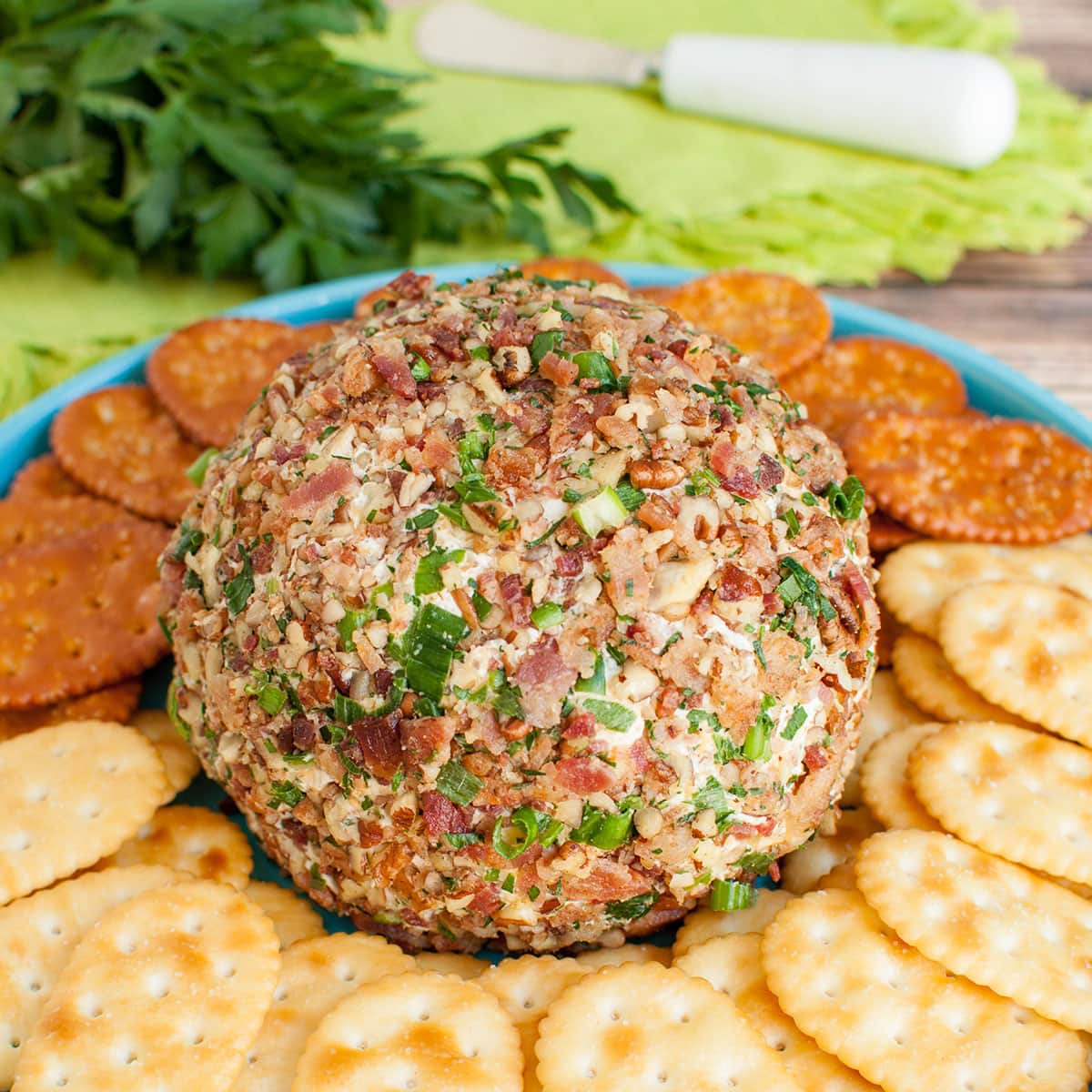 banch ranch cheese ball on teal blue platter with crackers