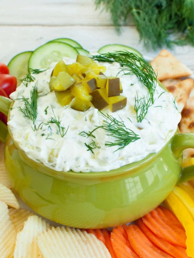 bowl of dip topped with chopped dill pickles