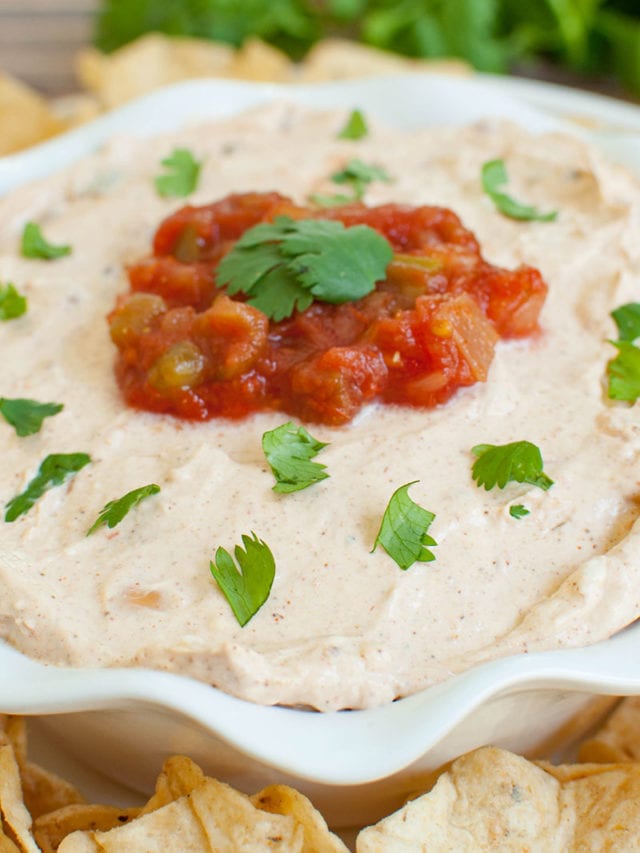 white bowl of dip topped with salsa and cilantro
