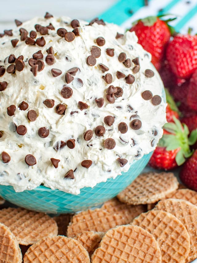 teal blue bowl of dip surrounded by cookies and strawberries